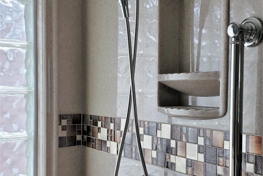 Onyx shower walls with tile stripe inlay and coordinating window trim